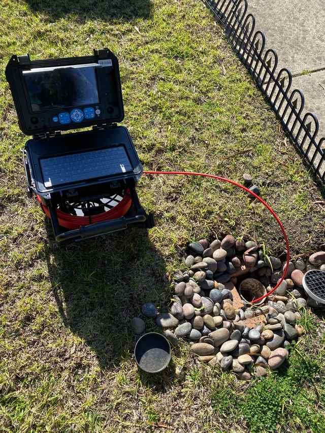 CCTV drain camera and reel set up beside an open inspection point in a Melbourne front yard